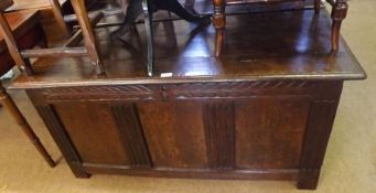 An 18th Century Oak Coffer with plank top and three panelled front, carved with foliage detail,