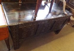 An 18th Century Oak Coffer with board top and three panelled front with later carved detail, 50”