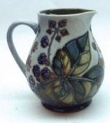 A Moorcroft Jug, decorated with the “Bramble” design on a pale blue and washed ground, 5 ½” high