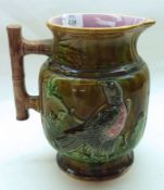 A 19th Century Majolica Jug, decorated with embossed design of a parrot on a treacle glazed
