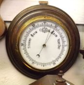 An early 20th Century Oak Framed Circular Aneroid Barometer, with opaque glass dial, brass bezel,