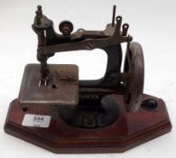 A Miniature Singer Sewing Machine on octagonal wooden base, total 9” long