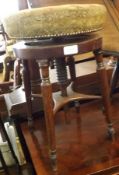 A Round Victorian Piano Stool with fabric-covered top and screw-thread height adjustment, raised
