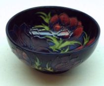 A Moorcroft Circular Bowl of tapering form, decorated with a version of the Anemone design on a dark