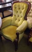 A Victorian Mahogany Framed Armchair with buttoned back, upholstered in golden fabric, raised on