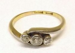 An early 20th Century 18ct Gold Ring of cross-over design, featuring three small Old Cut Diamonds,