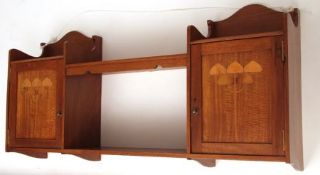 A late 19th Century Mahogany Wall Cabinet with two doors decorated with Art Nouveau style foliage