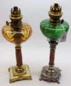 Two Oil Lamps with coloured glass fonts, both raised on polished marble pedestals to metal feet,