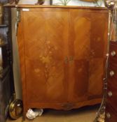 A 20th Century Continental serpentine front Cupboard, the two doors inlaid with floral detail