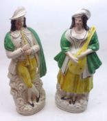 A pair of 19th Century Staffordshire Figures modelled as a Musical Couple, decorated in green and
