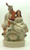 A 19th Century Staffordshire Figure Group, modelled as a Scots couple seated on a painted clock