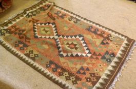 A 20th Century Kelim Rug, decorated with multi-coloured geometric designs on a mainly puce/ochre