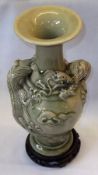 A 20th Century Celadon Green Glazed Vase, relief moulded with dragons, 11” high