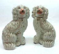 A pair of 19th Century Staffordshire Models of spaniels, typically shaped and decorated with gilt