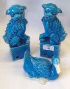 A pair of Oriental Majolica type Blue Glaze Models of temple dogs on pedestals; together with a