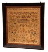 A large early 19th Century Framed Needlework Sampler, decorated with floral border, extensive