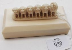An Ivory or Composition Carved Group of Six Dogs, raised on a rectangular plinth base, 5” long