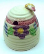 A Wilkinsons Clarice Cliff Bizarre pattern Honey Pot, lid with bee finial, decorated with floral