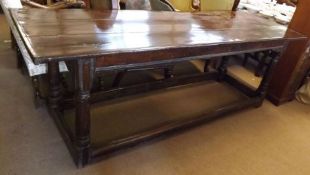 An 18th Century Oak Refectory Table, three plank top, raised on four turned legs to a stretcher