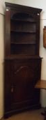 An early 19th Century and later Oak Two Piece Corner Cabinet, the open top section with shaped