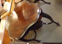 A late Victorian shaped oval Mahogany two tier centre Table, raised on four cabriole legs, with