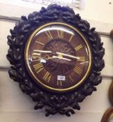 A European Circular Dial Clock, the framed carved with oak leaves and acorns and with a ribbon