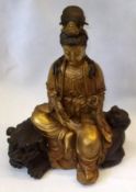 A 20th Century gilded Bronze Model of a seated Deity, seated on Bronze patinated Kaolin clutching