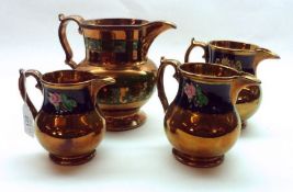 A Group of four graduated Victorian Copper Lustre Jugs, all decorated with floral highlights, (