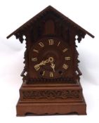 An early 20th Century Oak Cuckoo Clock, arched top over a central aperture and circular ivorine