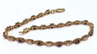 A yellow metal Sapphire and white stone-set Tennis Bracelet, stamped “9K”, 18cm long