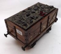 A Novelty Oak Moneybox, modelled as a GNR Coal Truck, the top decorated with pieces of coal, 11”
