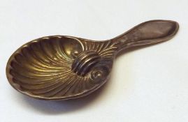An unmarked white metal Caddy Spoon with shell bowl