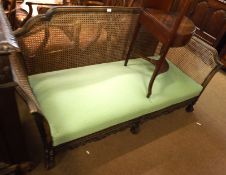 A large late 19th/early 20th Century Bergère Sofa, the cane sides and back to a green upholstered