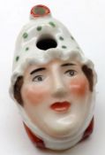 An unusual novelty Pen Stand modelled as a head of a young girl wearing a spotted mop cap ,