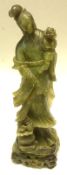 A large Oriental Jade or Jadeite Figure of a Young Girl clutching a sprig of Foliage, 20th Century,