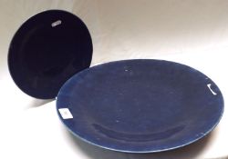 An Oriental Blue Glaze Charger; a further similar smaller Dish, both of circular form, in plain