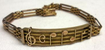 An unusual early 20th Century 9ct Gold Bracelet, a curved and pierced panel in the form of a musical