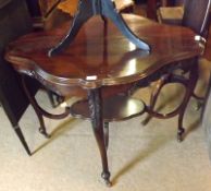 A late Victorian shaped oval Mahogany two tier centre Table, raised on four cabriole legs, with