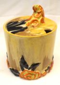 A Clarice Cliff “My Garden” Cylindrical Covered Preserve Pot, the body with brown and ochre