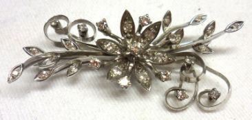 An unmarked precious metal all small Diamond set Spray Brooch with flower head centre, 55mm x 26mm