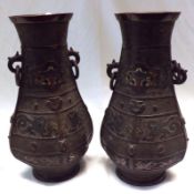 A pair of Japanese Bronze two handled Vases of ovoid baluster form, applied on either side with ring