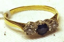 A hallmarked 18ct Gold centre mid-blue small Sapphire and two small brilliant cut Diamond Ring