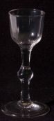 An 18th Century Wine Glass with bucket bowl, ballustroid stem terminating in a spreading circular