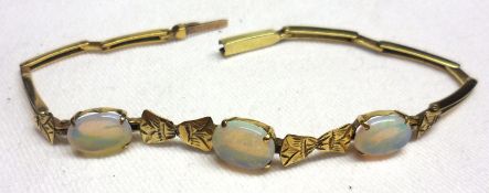 A late 19th/early 20th Century Flexible Link yellow metal Bracelet, set with three Opals (one