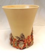 A Clarice Cliff Trumpet Vase, with plain pale puce body and coloured relief moulded floral foot,