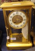 An early 20th Century French Gilt Metal Cased Four Glass Clock, inset with bevelled glass panels and