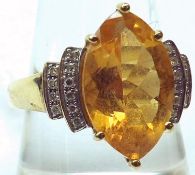 A hallmarked 9ct Gold centre Marquise shaped Citrine Ring with small brilliant cut Diamonds to the