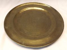 An Eastern Brass or Bronze Circular Plate, incised floral and mythological decoration, 8 ½” diameter