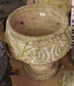 A round Weathered Concrete Garden Urn, with embossed floral detail on a round pedestal base, 19”