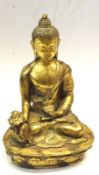 An Oriental gilded Bronze Figure of a seated Deity clutching a Sensor in his left hand and wearing